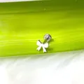 Primer plano de un piercing plateado en forma de lazo con cierre de base plana labret - Lazo
