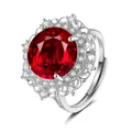 Detailed macro view of an ornate ring featuring a large red zircon and silver floral lace setting - Adjustable Open / Ruby