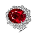 Macro view of luxurious oval cut ruby ring with double layered diamond floral halo - Adjustable Open / Ruby Red