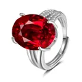 Macro shot of silver metal ring featuring large oval ruby stone and pavé set diamonds - Adjustable Open / Ruby Red (QHJ008)