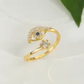 Macro detail of gold open ring featuring blue evil eye charm and clear zircon stone - Adjustable Open / Gold