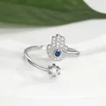 Macro shot of silver Hamsa Hand ring with evil eye blue stone and sparkling zircon detail - Silver