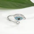 Detail of evil eye adjustable ring with blue crystals and green leaf on white background - Eye Open Adjustable / Silver
