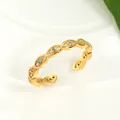 Detail of golden Evil Eye ring with turquoise stones and zircons on white tray - Adjustable Open / Gold