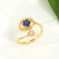 Detail of gold evil eye ring with blue stone and sparkling diamonds on white ceramic - Gold