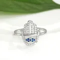 Macro shot of silver Hamsa hand ring featuring blue Evil Eye and white zircon inlay - Adjustable Open / Silver