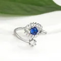 Detailed close-up of Evil Eye silver open ring with blue stone and floral zircon accents - White Gold