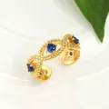 Detailed view of adjustable gold ring with three blue stones and beaded texture - Gold