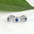 Detailed macro view of an adjustable silver Evil Eye ring with blue round gemstones - Silver