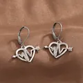 Close-up of silver heart earrings with heartbeat line and arrow on brown silk - Silver