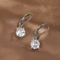 Detail of four-prong lever-back earrings with round cubic zirconia on brown silk - White Gold