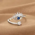 Macro shot of silver evil eye ring with blue stone and star on brown satin - Evil Eye Crown Style (Q-J083) / White Gold