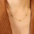 Elegant gold plated stainless steel daisy necklace with five floral charms worn by model - 40+5cm / Gold