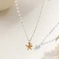 Elegante collar de perlas con colgante de estrella de mar en oro mate sobre fondo beige - Collar de estrella de mar de perlas / Dorado