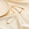 Detail van 18K goudvergulde slangenketting met parelhanger op crèmekleurige zijden stof - Ronde Kraal Parelstijl (QYH312)