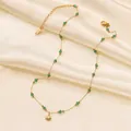 Detalle de colgante de concha dorada y cuentas verdes en cadena fina sobre seda - Collar de Concha con Cuentas Verdes (H6146) / Dorado