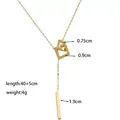 Detail of golden Y-necklace featuring interlocking squares and a sleek metal bar pendant - Gold