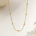 Minimalist gold snake chain necklace with oval beads shown against a soft beige background - Oval Bead Chain (XKN0364)