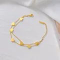 Detail der 18K vergoldeten zweilagigen Fußkette mit Herzanhängern auf weißem Seidenhintergrund - Doppellagiges Herzarmband (Gold) (XKB0039)
