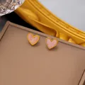 Macro view of heart-shaped earrings with pink marble texture and gold metal frame - Pink Marble Heart Stud (XKE0148)