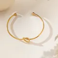Detailed close-up of 18K gold plated knotted open bangle with elegant ball end caps - Beaded Knot Style (XKB2176)