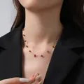 Collana a catena dorata con pietre naturali rosse su modella che indossa un blazer nero - Collana Pietra Rossa Irregolare Oro