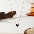 Detailed close-up of golden heart pendant necklace with black onyx and millgrain edges - Black Shell Heart Necklace (XKN0183)
