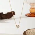 Close-up of golden heart necklace with white mother-of-pearl inlay and beaded edge detail - White Shell Heart Necklace (XKN0191)