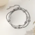 Detail of silver layered snake chain necklace with polished beads and lobster clasp closure - Oval Bead Snake Chain Bracelet (XKB0071) / Steel