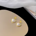 Boucles d'oreilles cœur dorées avec perles, gravure Love et finition en émail blanc - Clous de Coeur en Nacre / Or