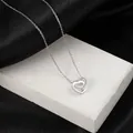 Silver interlocking heart necklace with titanium steel cross chain on silk background - Steel