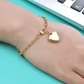 Nahaufnahme des goldenen Herzanhänger-Armbands am Handgelenk mit Polierschliff - 17cm / 18K-Gold