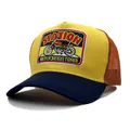 Primer plano del bordado de moto retro en la gorra trucker amarilla y azul con rejilla - Ajustable / Amarillo