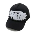 Streetwear trucker hat with graffiti print and metal cross detail on a black mesh base - Black (White Print)