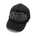 Detail of black trucker hat featuring 3D foam graffiti print and silver cross emblem - Black (Gray Print)