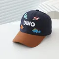 Detailed close-up of a kids' navy baseball cap featuring 3D DINO embroidery and colorful patches - 50-54CM Circumference / Navy Blue
