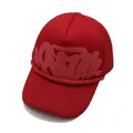 Close-up of red foam print Corteiz lettering and mesh texture on a trucker hat - Red