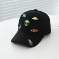 Detailed close-up of cosmic alien and rocket embroidery on a black cotton kids baseball cap - Small/Adjustable / Black