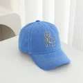 Detail van T-Rex borduursel en witte contraststiksels op de blauwe katoenen baseballpet - Verstelbaar / Hemelsblauw