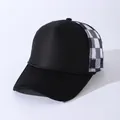 Side view of a black trucker hat featuring breathable black and white checkered mesh - Adjustable / Black