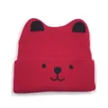Detailed close-up of a red knitted baby hat with cute black cat ears and embroidered face - One Size / Red