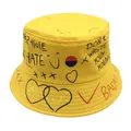 Λεπτομέρεια από κίτρινο βαμβακερό καπέλο bucket με μαύρα και κόκκινα γκράφιτι σχέδια - M / Κίτρινο