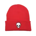 Gros plan sur le bonnet en tricot rouge avec broderie d'alien détaillée sur le bord replié - Taille unique / Rouge avec étiquette blanche