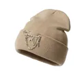 Detail of beige ribbed knit beanie featuring silver butterfly and cross chain pendants - One Size / Khaki