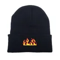 Knit beanie hat in black featuring vibrant red and yellow flame embroidery on the cuff - One Size / Black