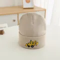 Close-up of beige knitted kids beanie featuring a cute yellow excavator embroidery - Off White
