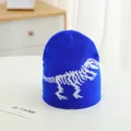 Dettaglio del cappello in maglia blu acceso con motivi jacquard di scheletri di dinosauro - Taglia unica / Blu