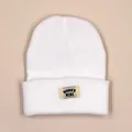 Close-up of white knitted beanie with MAMA'S MINI woven label on the folded brim - 1-3 Years / White
