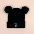 Close-up of black knit baby beanie with double faux fur pom-poms and green crocodile embroidery - 1-3 Years / Black