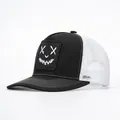Close-up of the mesh back and graffiti smile face patch on the black trucker hat - Black & White